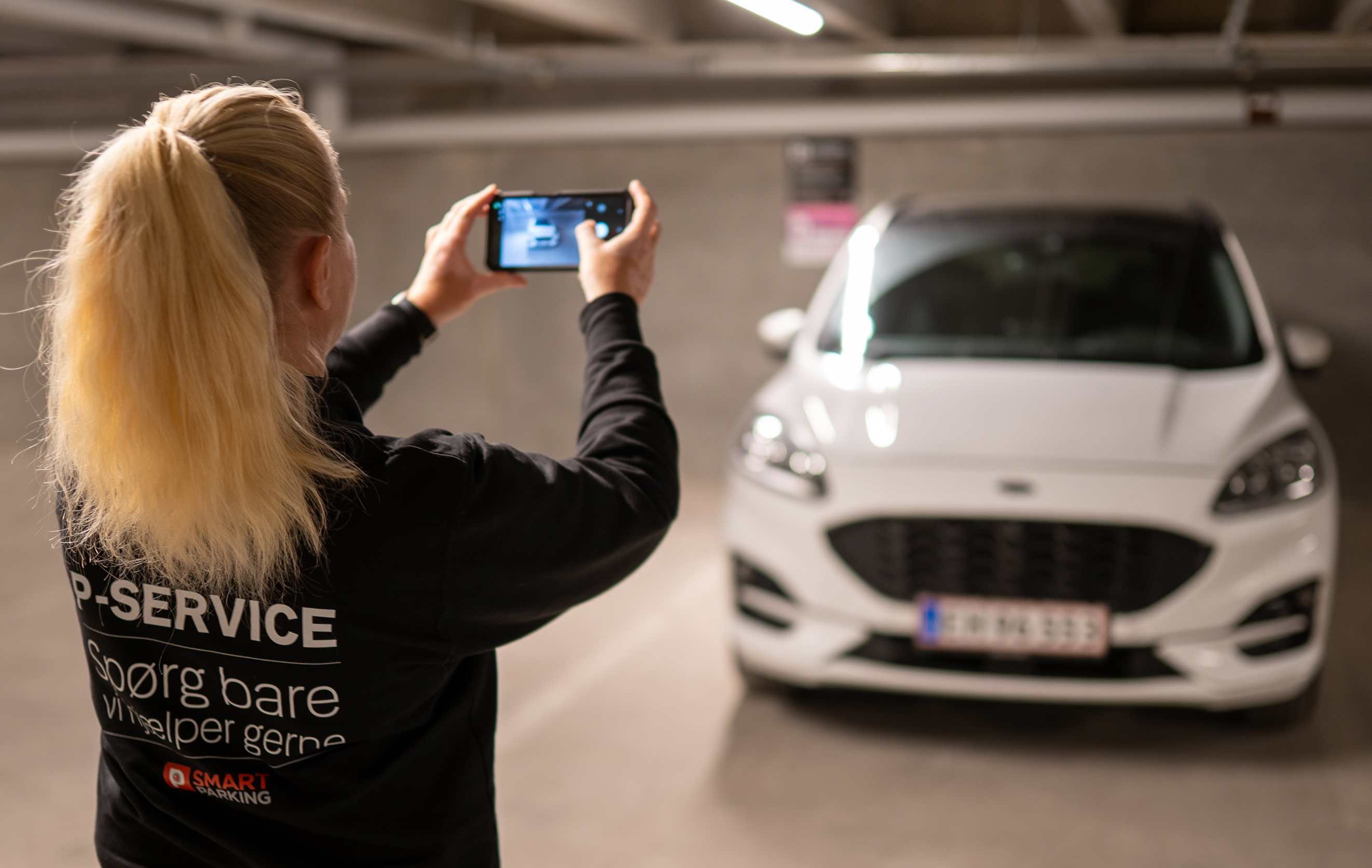 Parkeringsvagt udfører pareringskontrol på parkeringsplads