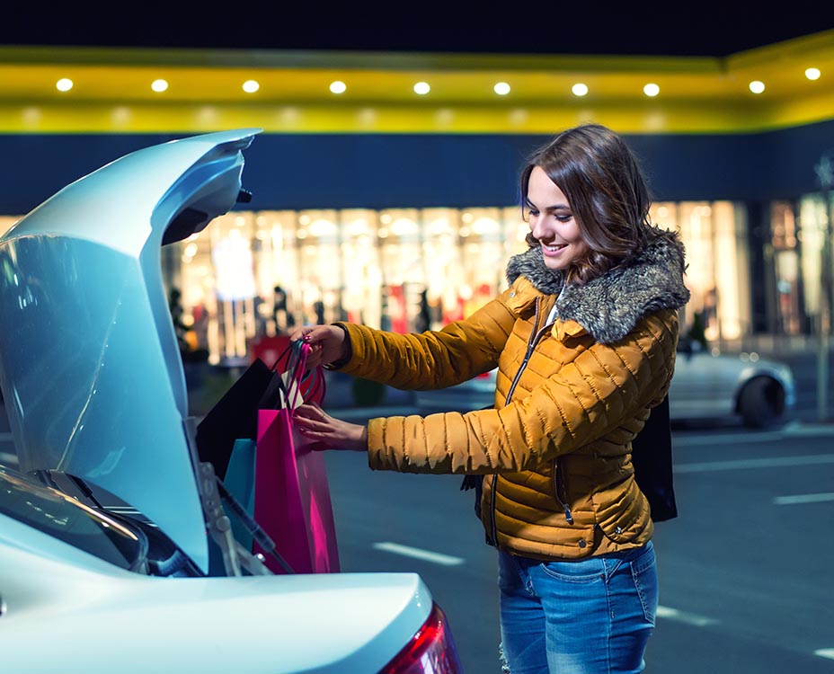 Woman putting shopping bags in the car