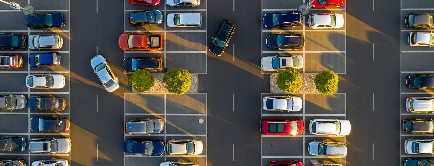 An aerial view of a parking lot filled with parked cars.